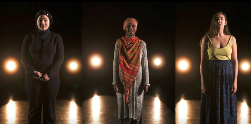 Three people standing on stage with lights behind them. 