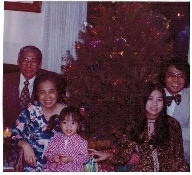 Family sitting in front of christmas tree