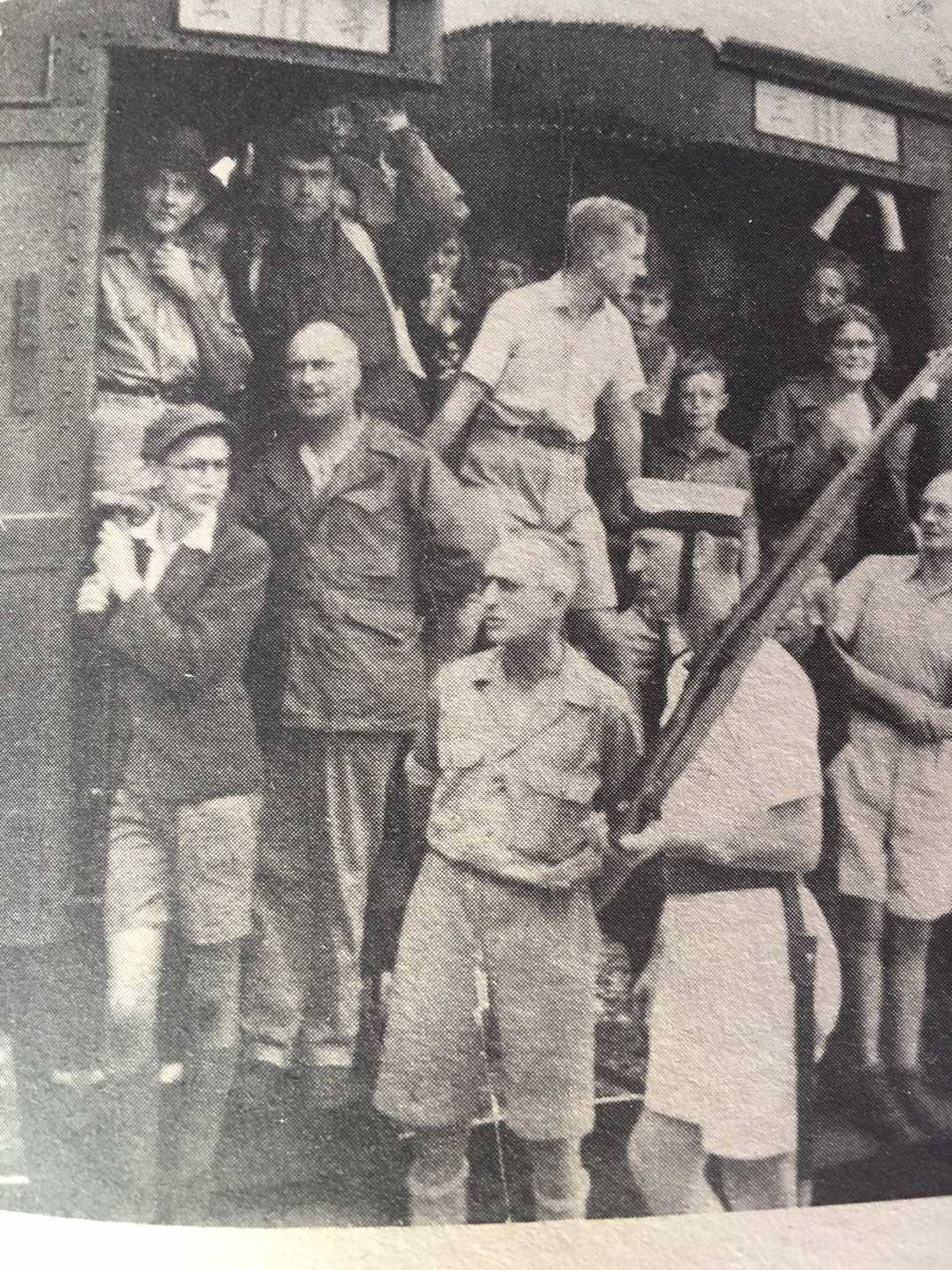 Group of students and soldiers staring into distance with concerned looks on their faces