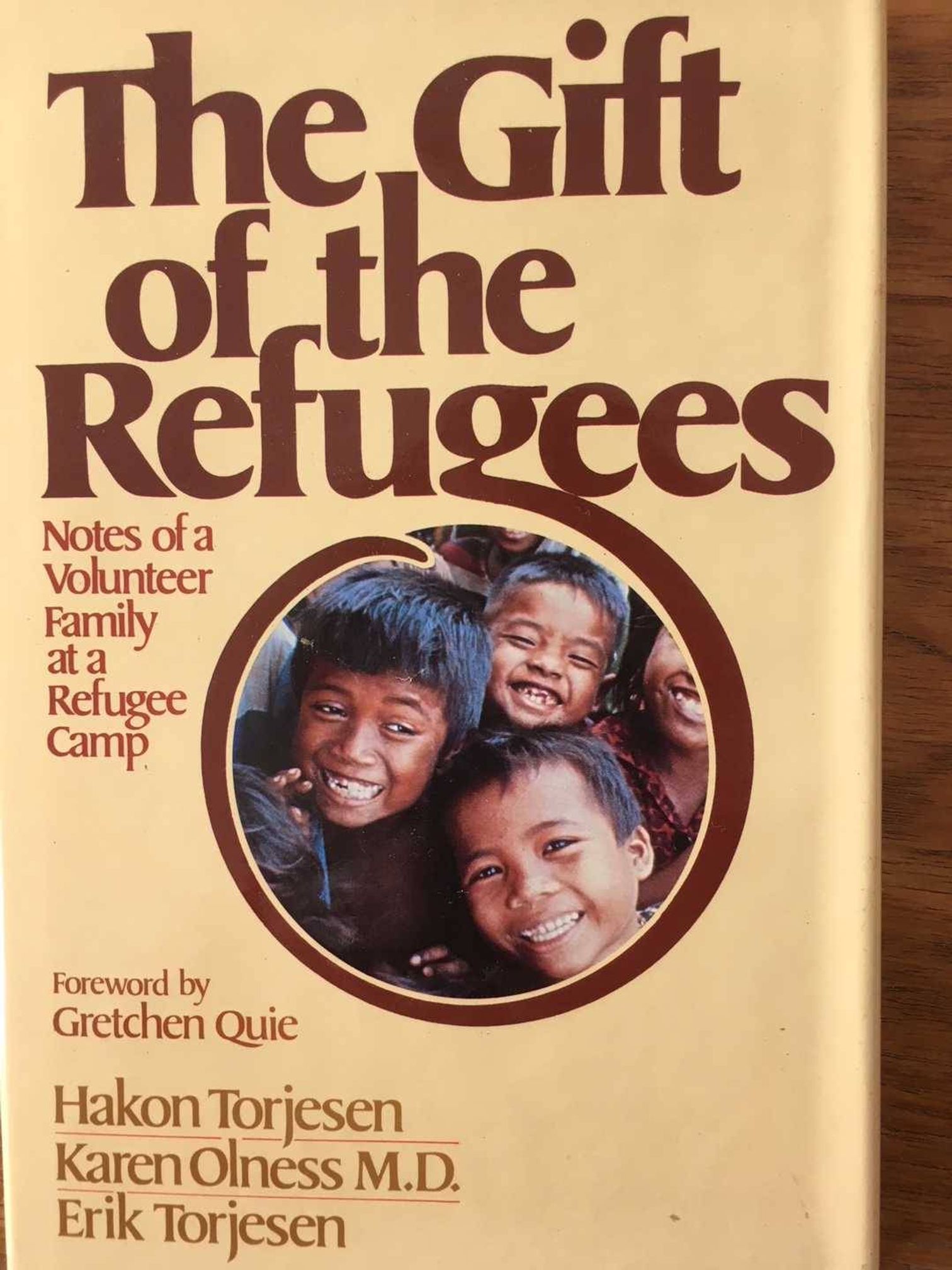 Cover of book that reads "The Gift of Refugees" featuring image of smiling group of children