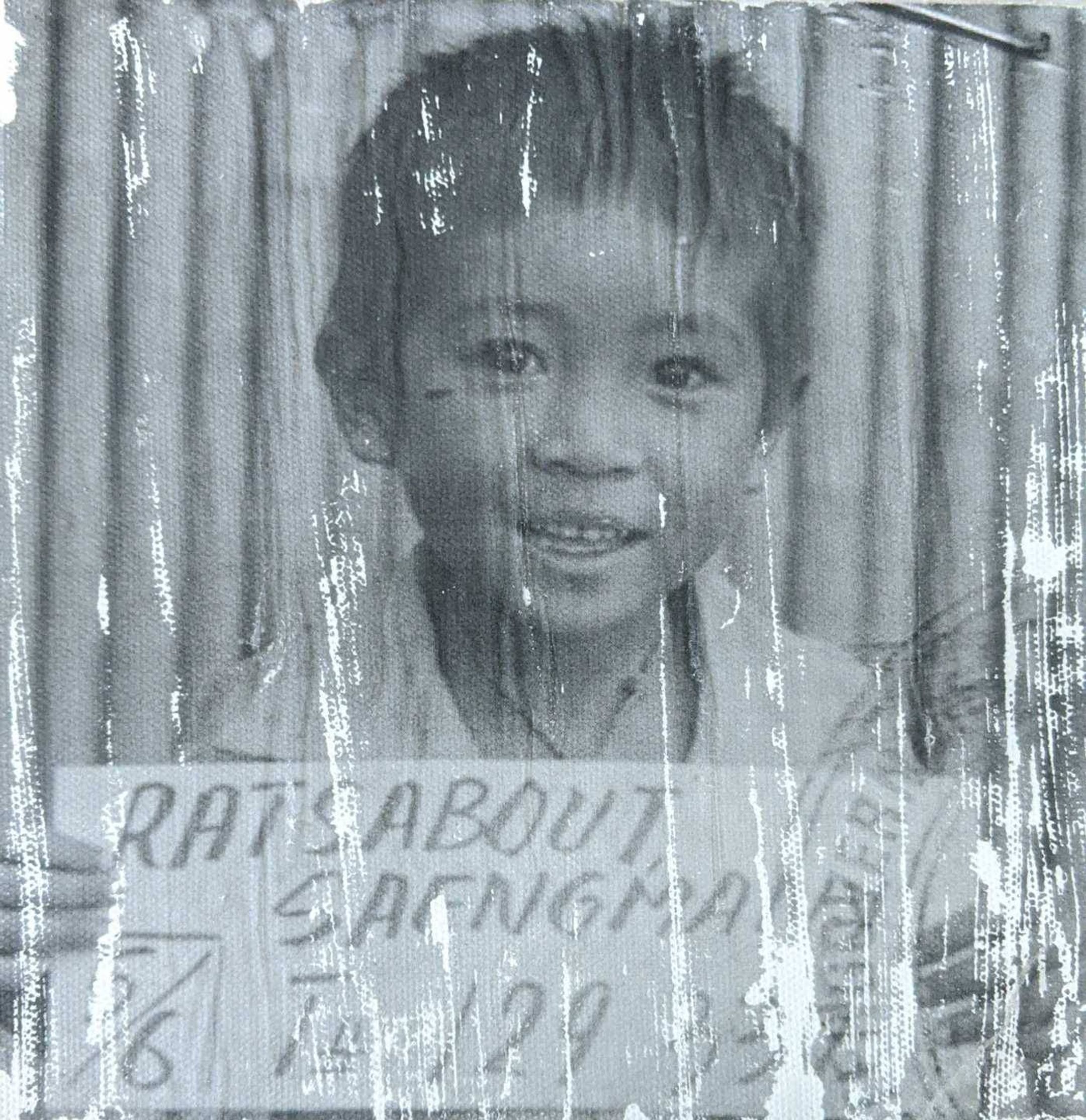 Child with smile holding sign that reads Ratsabout Saengmany