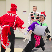 two men play fighting dressed as chickens