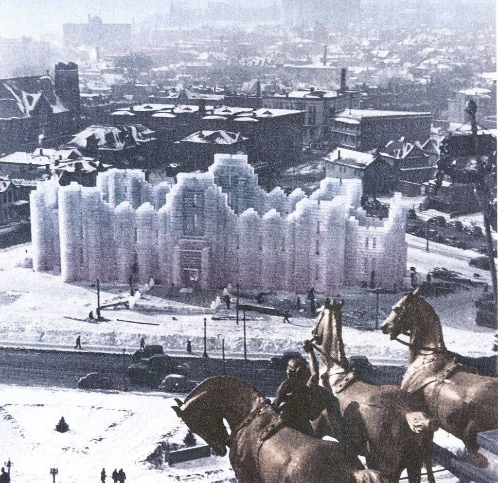 Statue of three horses in the foreground, the 1937 ice palace designed by Clarence Wigington in the midground with St. Paul in the background