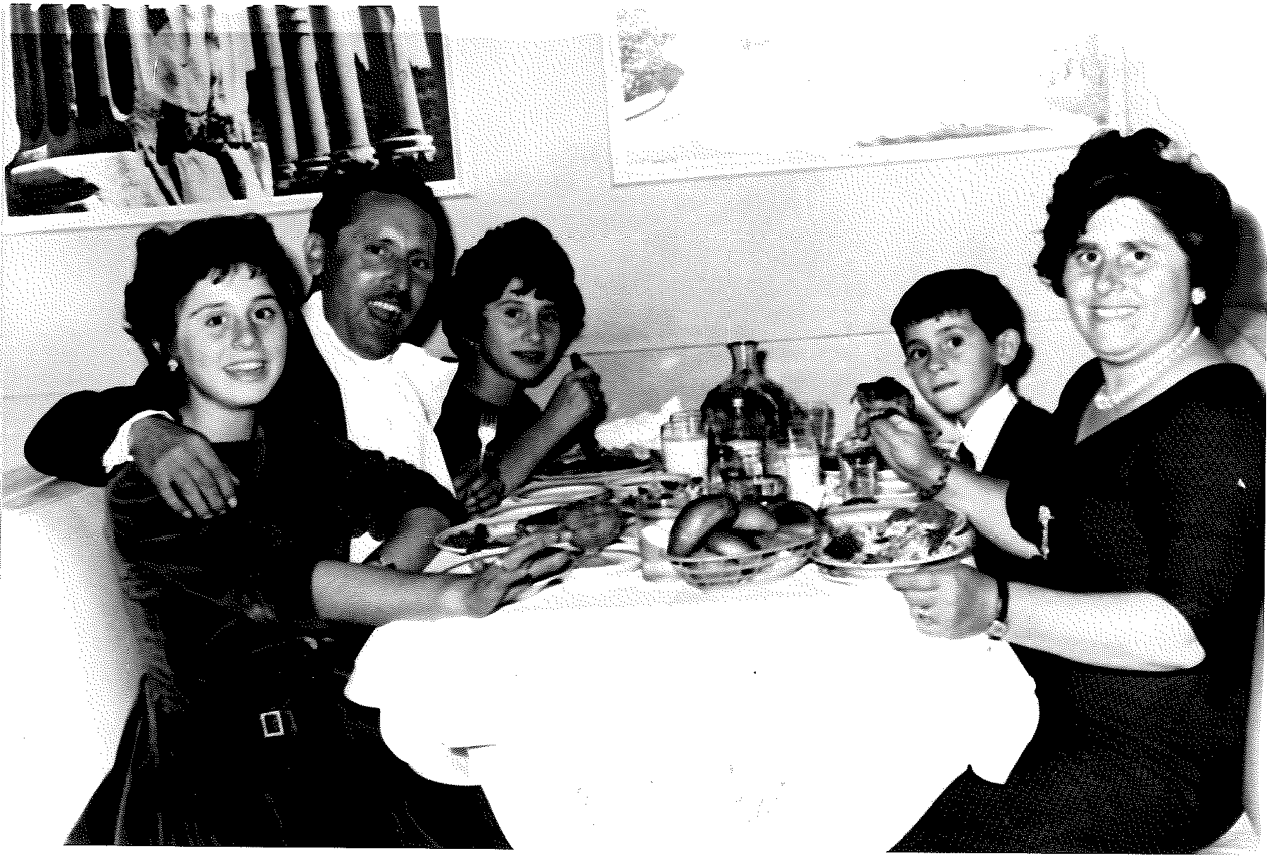 Family of five sitting at a table eating food