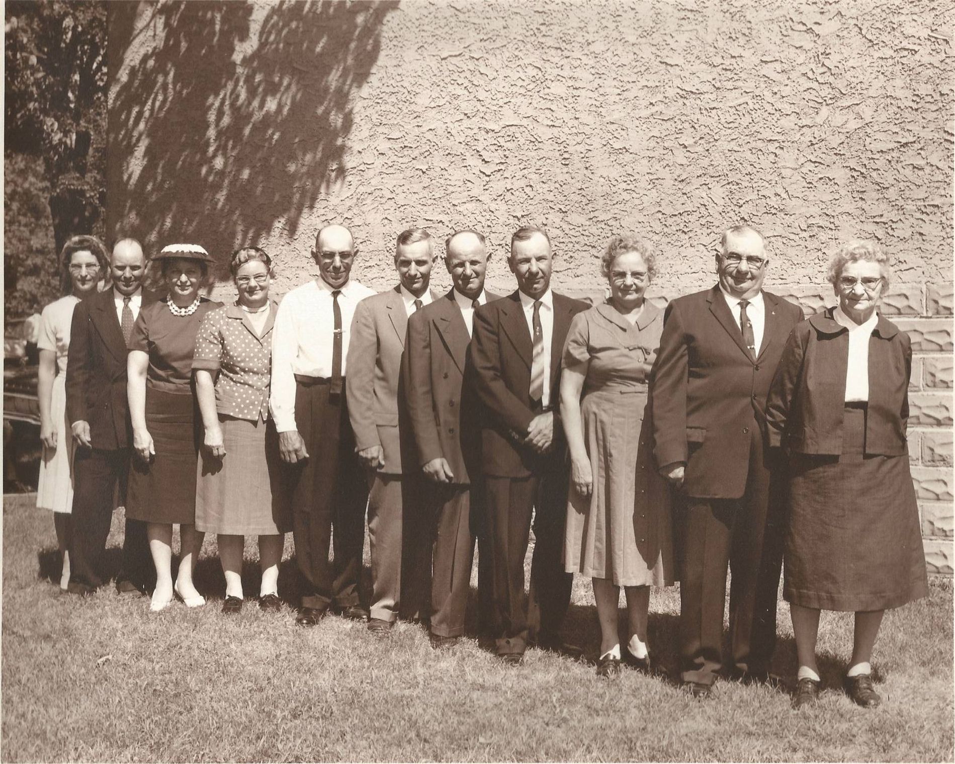 Line of older people dressed in formal clothes posing for camera