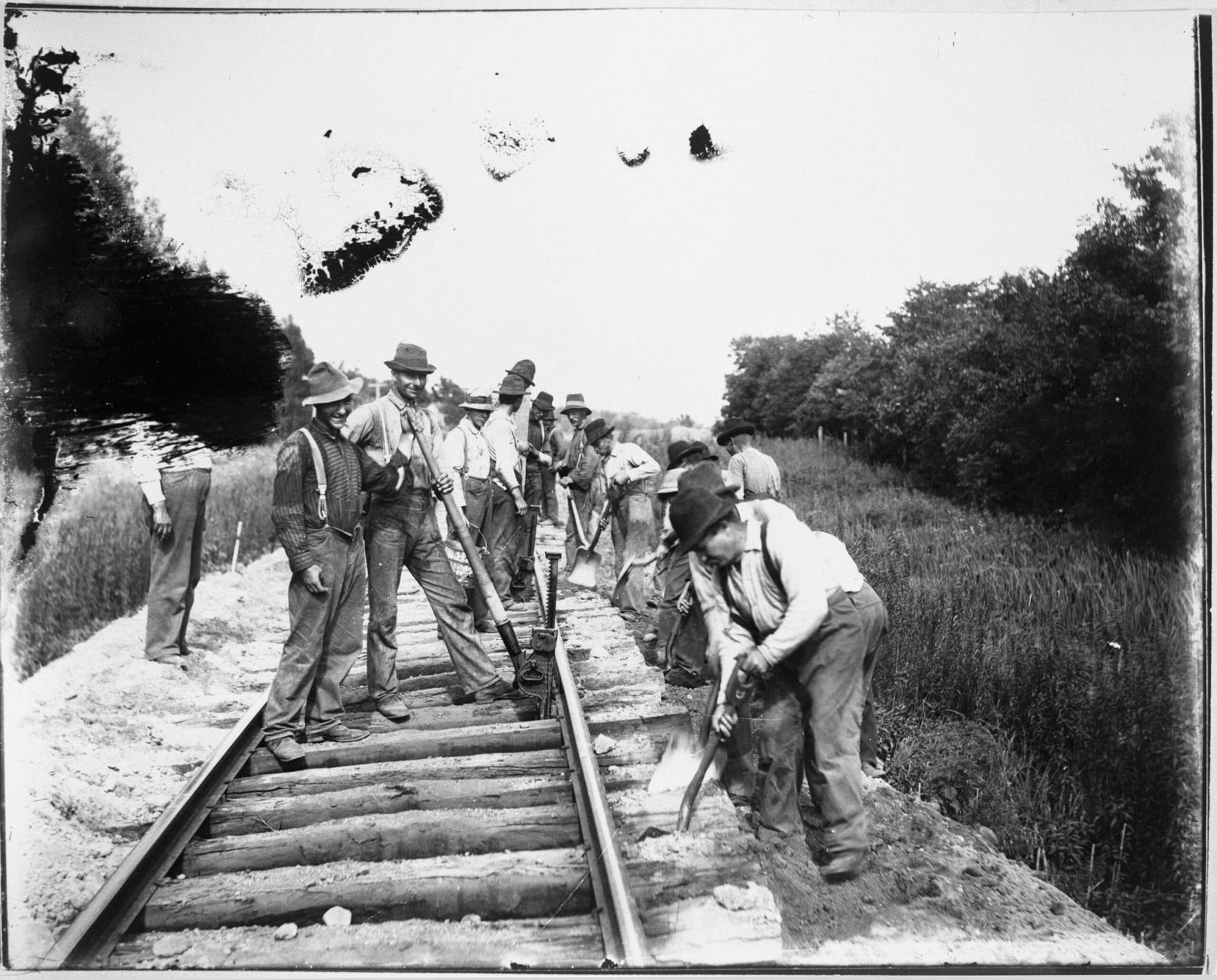 Swedish railroad workers, shoveling dirt where new railroad pieces were just installed
