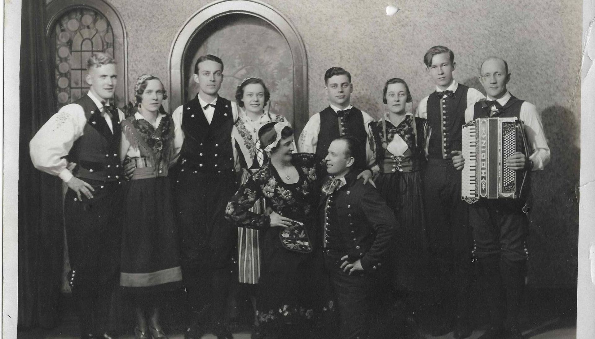 Group of performers standing in formal clothing and holding instruments
