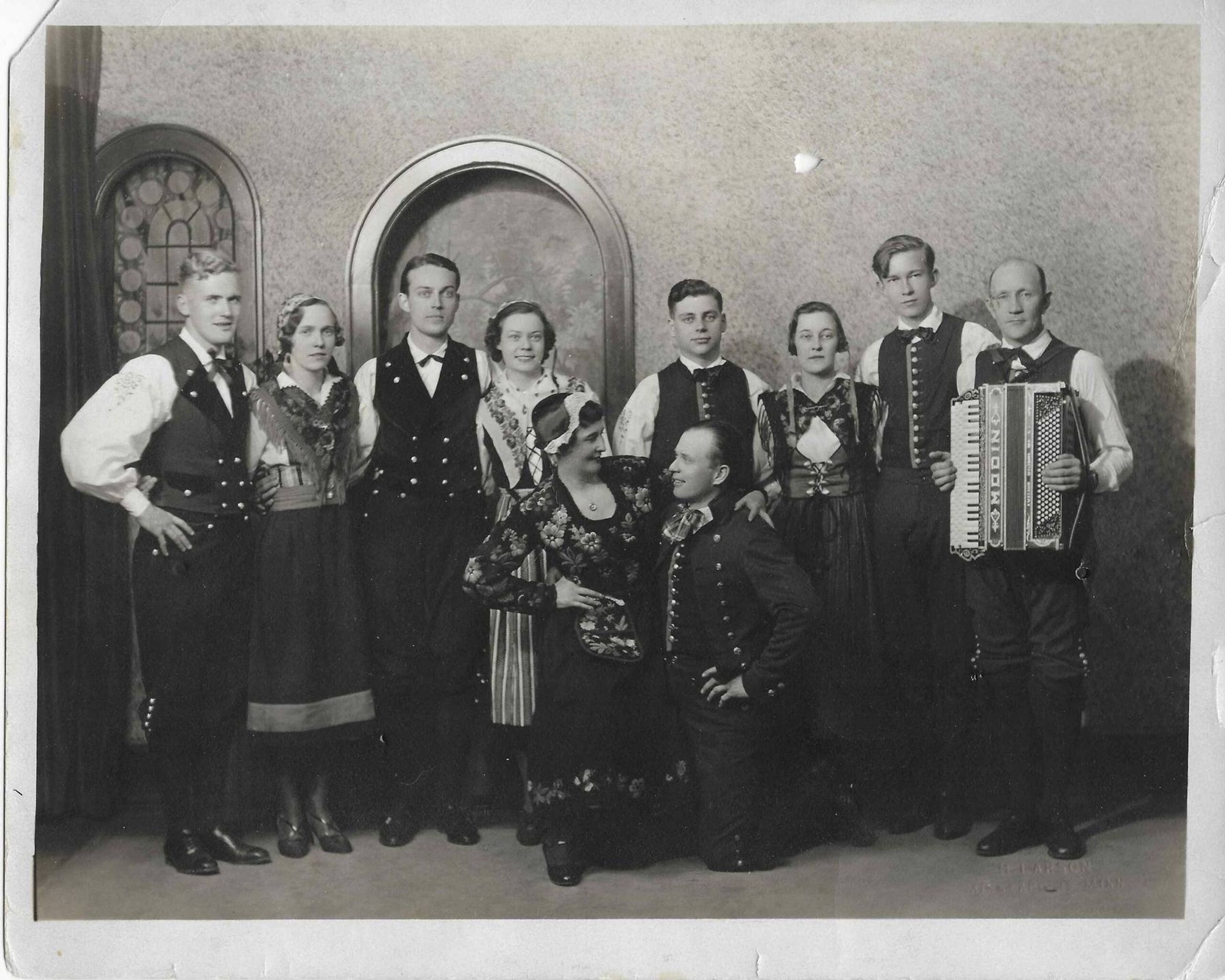 Group of performers standing in formal clothing and holding instruments