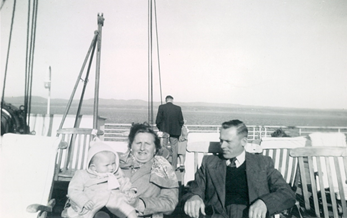 Two parents holding a baby onboard a boat