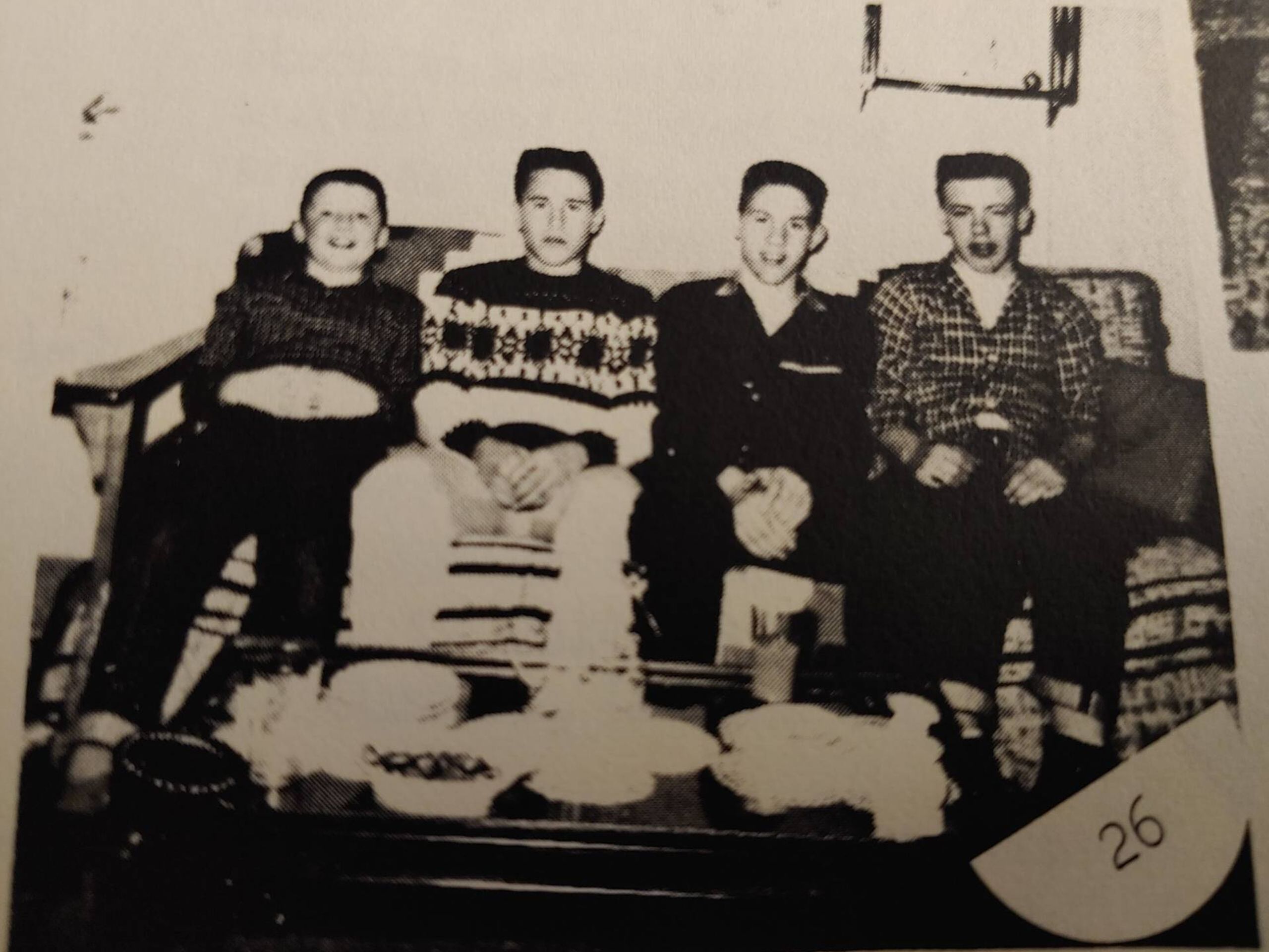 Four children seated on a couch smiling