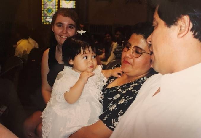 Child at a church surrounded by family