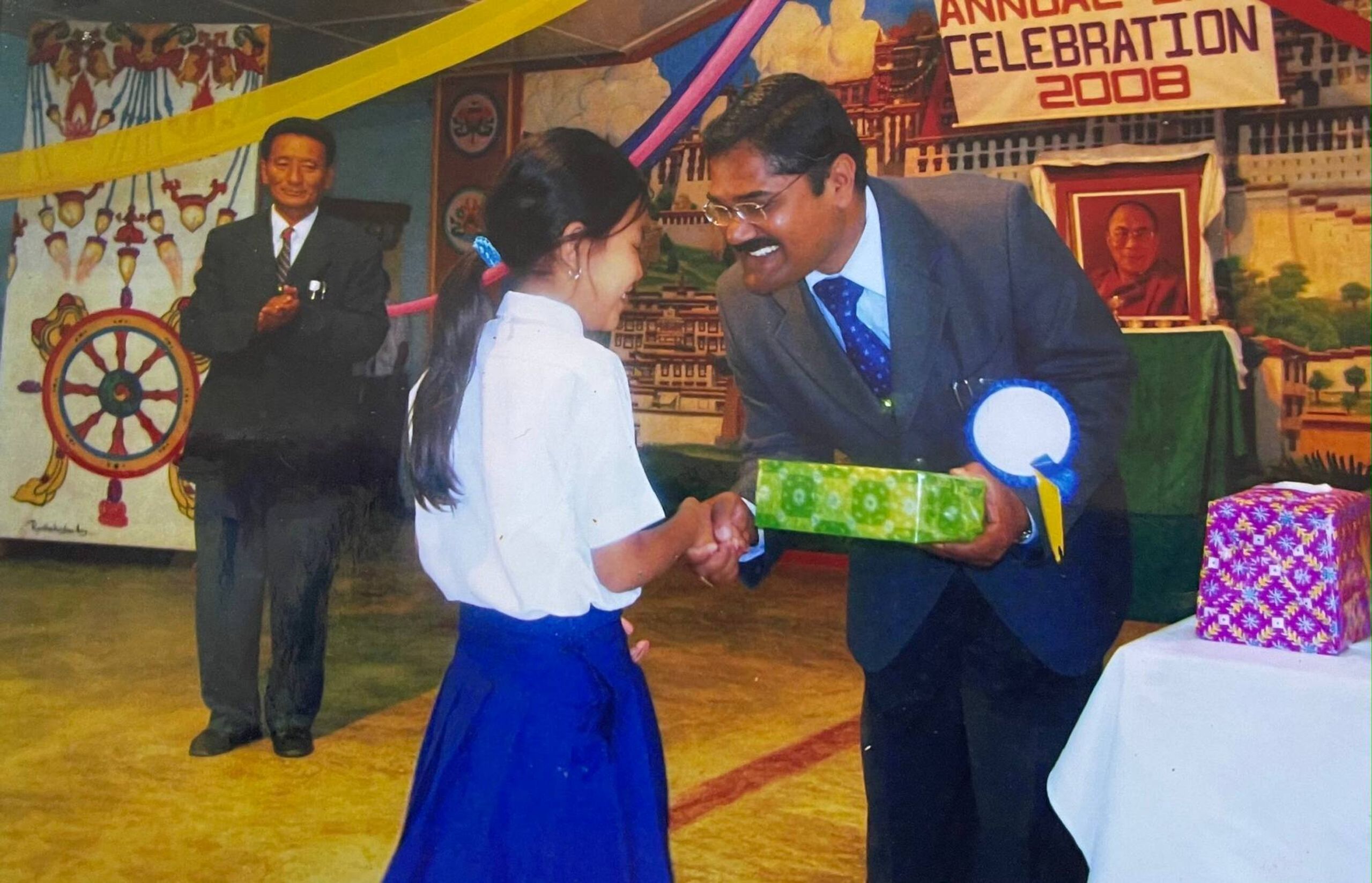 Young girl shaking the hand of an older man dressed formally