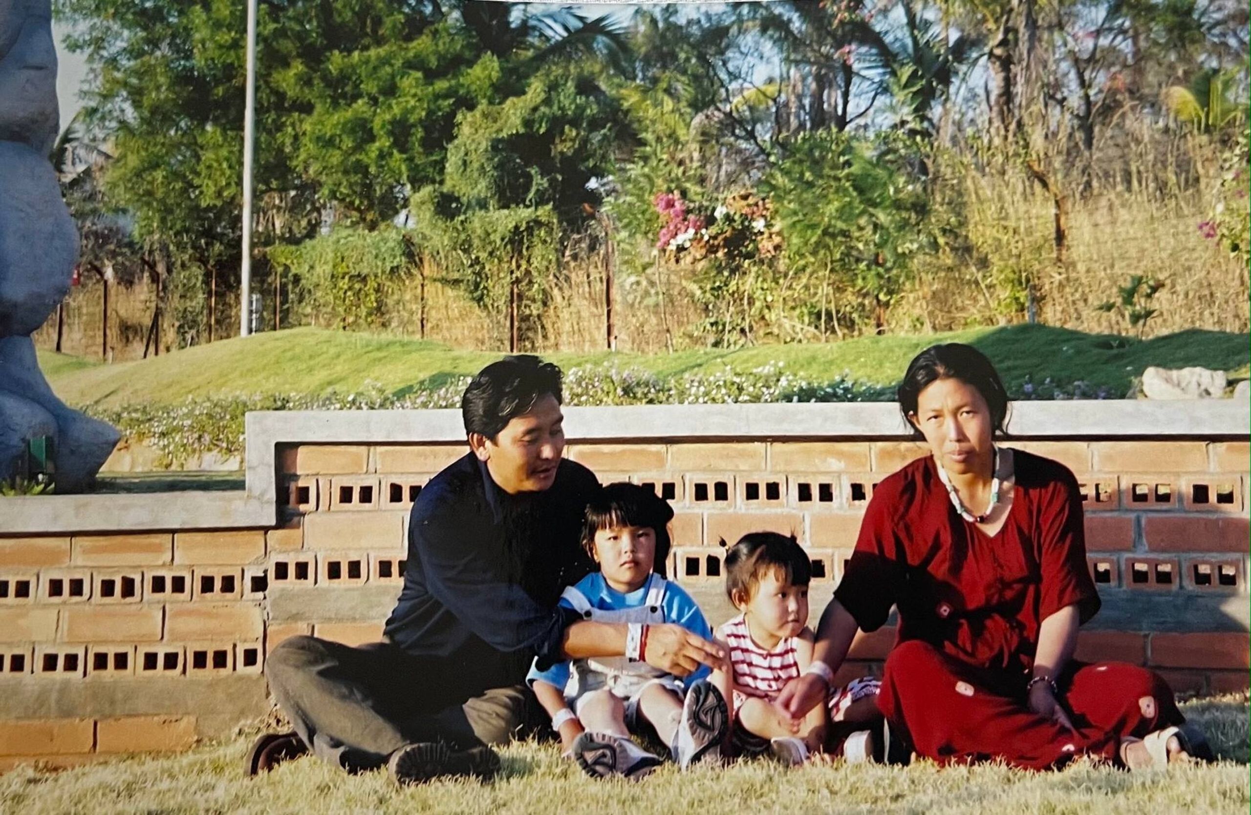 Two parents and two children seated at a park