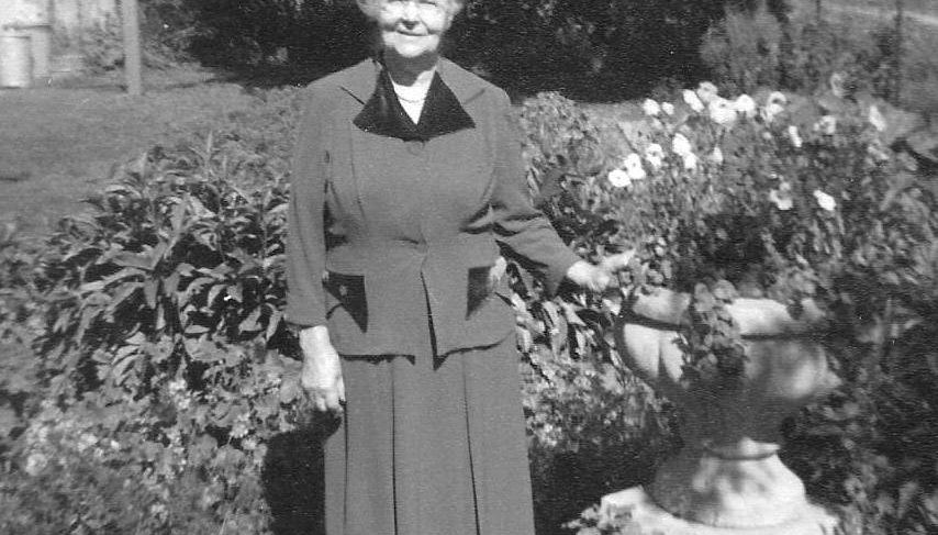 Older woman standing in a garden wearing a dress