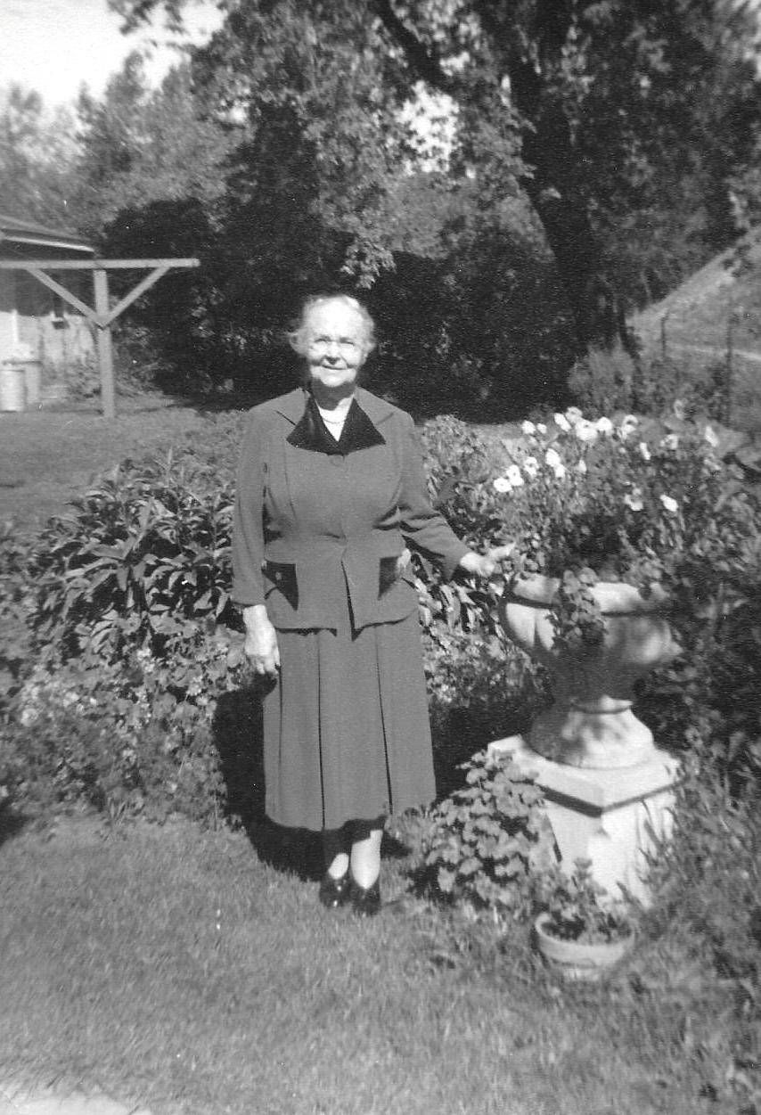 Older woman standing in a garden wearing a dress