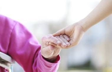 Caregiver holding patients hand
