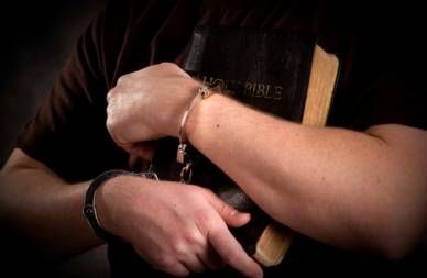 close up of prisoner's arms around bible
