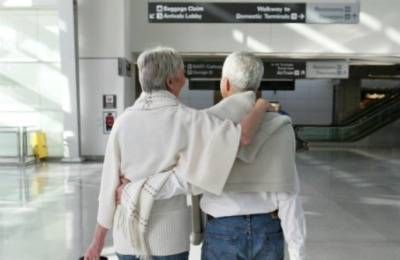 mature couple arm in arm walking thru airport