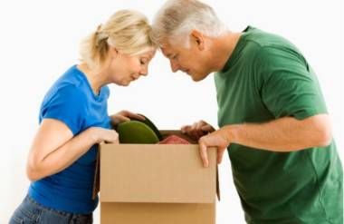 mature couple peering into moving box