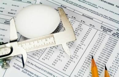 measuring egg against financial papers