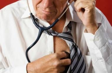 man with stethoscope checking his own heart rate