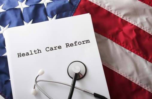 Health Care Reform Bill Law on US flag with stethescope