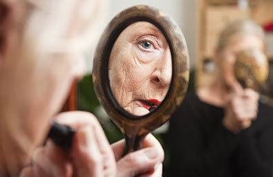 Woman looking in handheld mirror