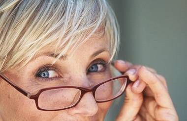 Close-up of woman looking over glasses