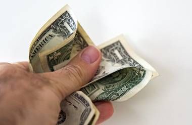 Man crushing dollar bill in his hand