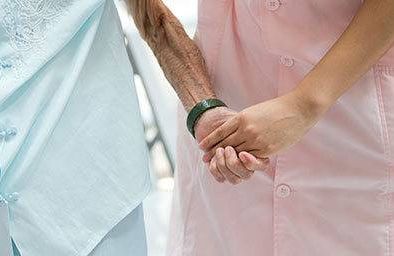 Nurse and patient holding hands