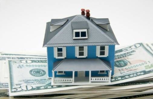 Miniature house on stack of money