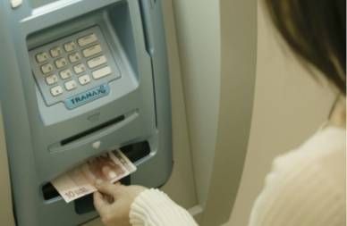 Woman withdrawing Euros from ATM machine