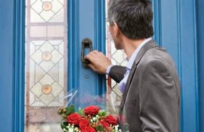 man knocking on door with flowers
