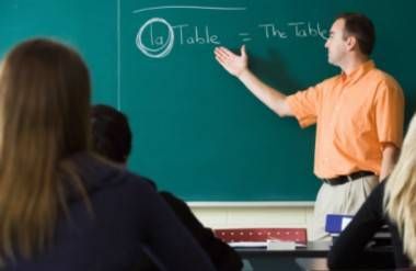 teacher pointing to chalkboard during french class