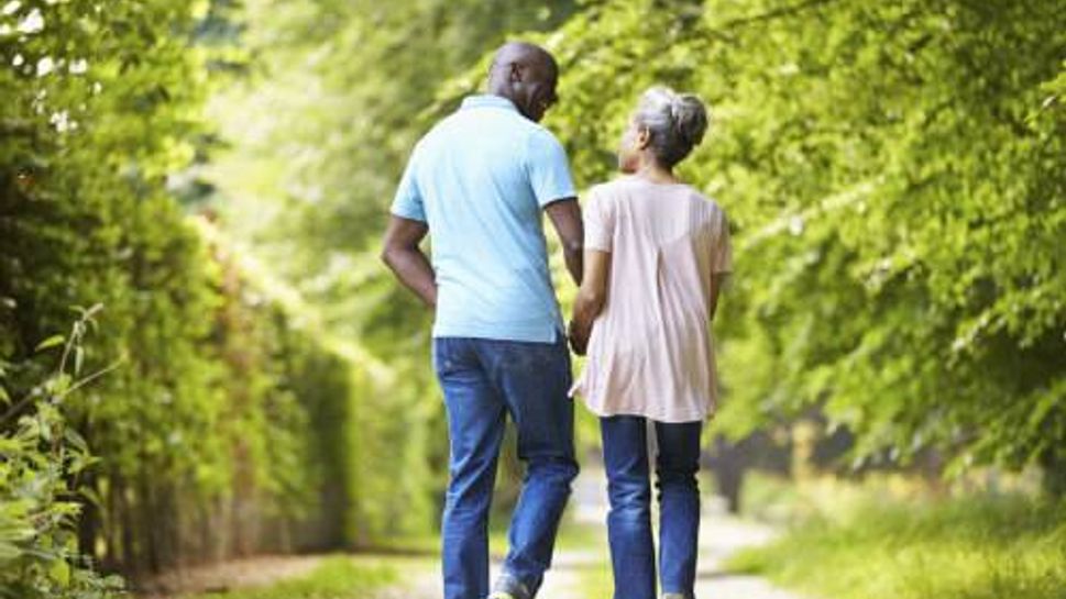 Mature African American Couple Walking In Countryside