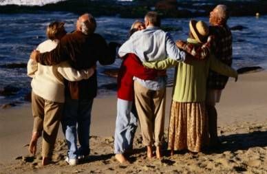 Three Couples Laughing and Hugging on the Beach