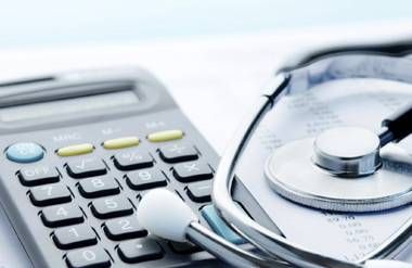 Calculator, stethoscope and medical costs