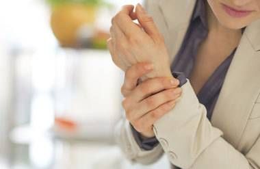 a woman holding her hands in pain, from arthritis