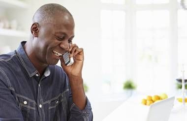 Man talking on phone and using computer