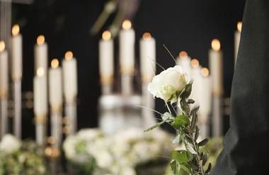Man holding white rose at funeral