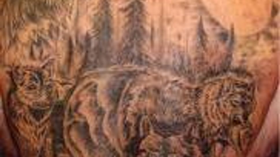 large back tattoo of pack of wolves in forest
