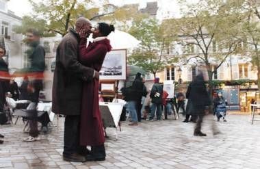 African-American couple kissing in European outdoor plaza