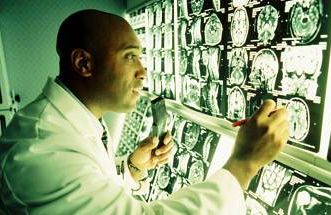 an african american doctor looking at brain mri scans
