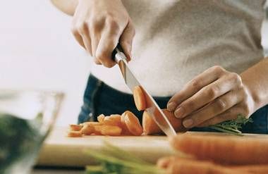Woman chopping carrots at the kitchen counter