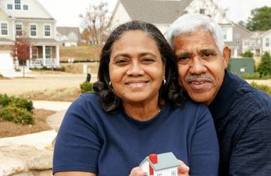 an older minority couple buying a house