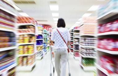 Woman shopping in aisles of supermarket