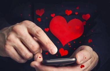 Man typing message on a smartphone with illustrated hearts