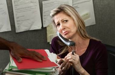 Woman overwhelmed frowning at work