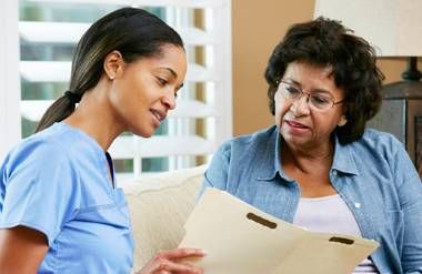 Nurse discussing records with female patient