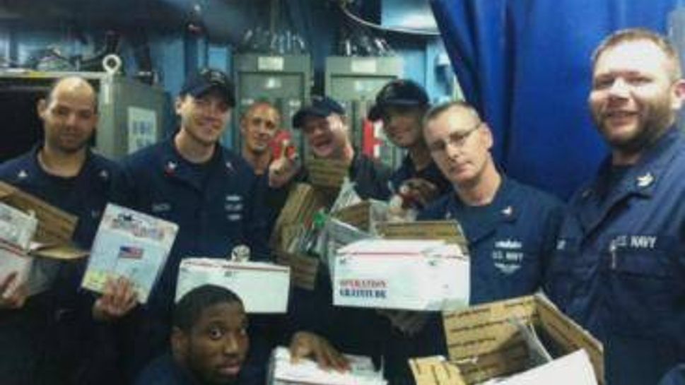 U.S. Navy sailors open care packages from Operation Gratitude.